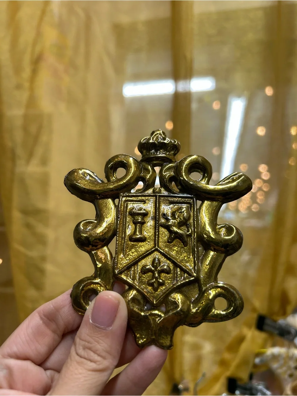 vintage gold-toned or brass-plated metal coat of arms or family crest decorative